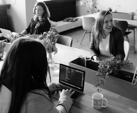 three women sitting around a desk